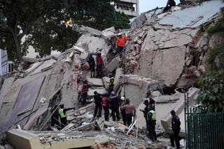 Rescuers search for victims in a collapsed building